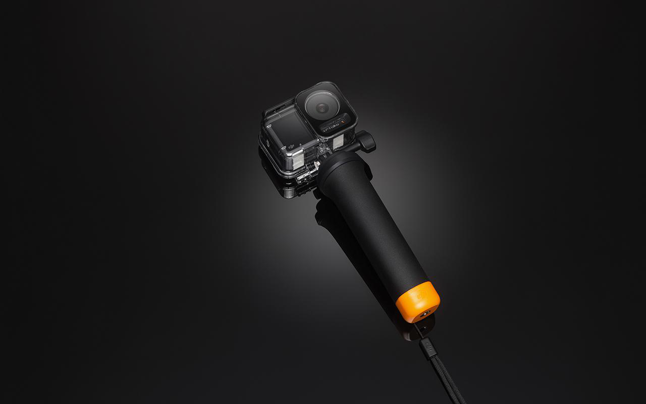 Schwarze Kamera mit schwarzem Griff und orangefarbenem Akzent.