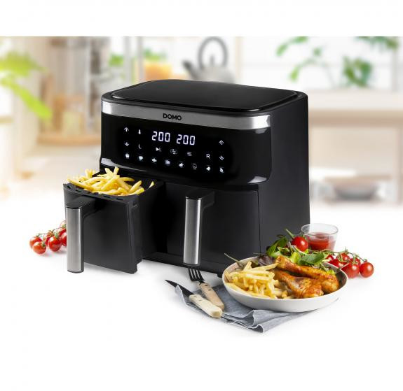 Black and silver air fryer with french fries and other cooked food.