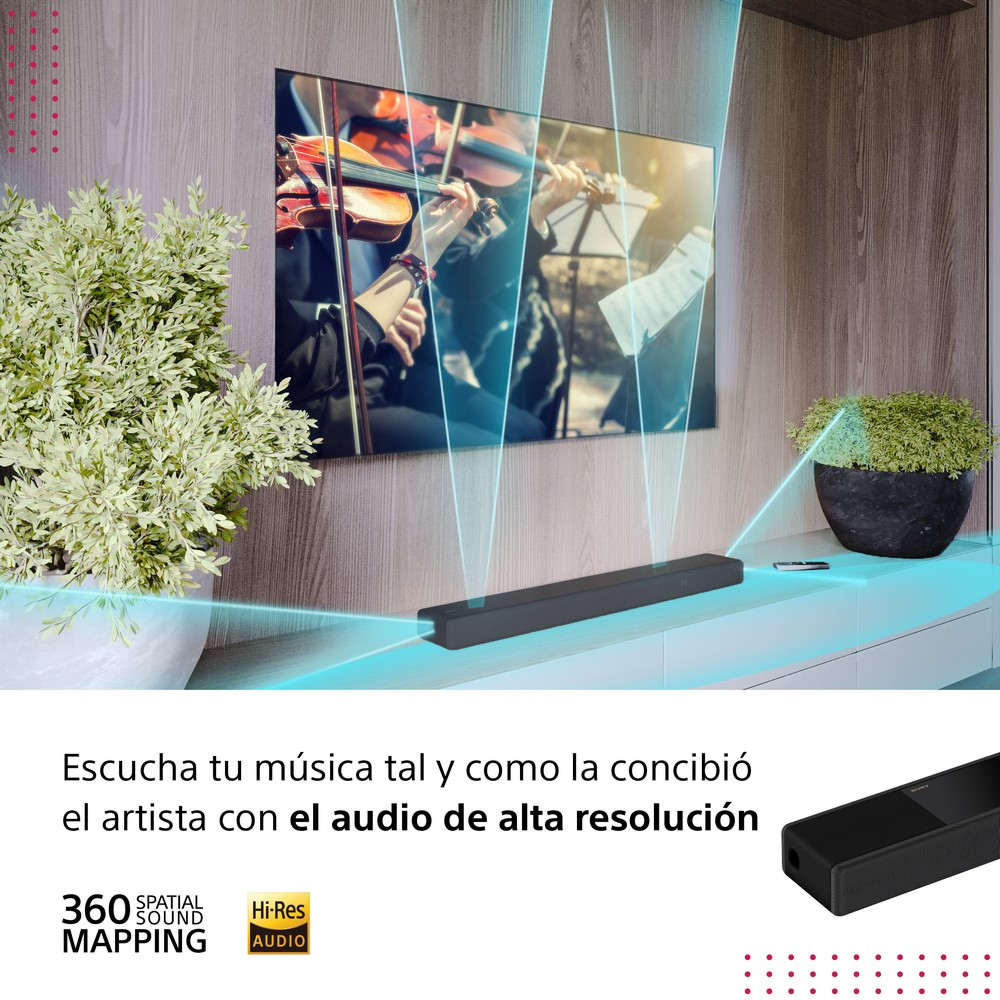 Una pantalla de TV muestra una escena de concierto. Una barra de sonido está debajo del televisor, y plantas al lado.