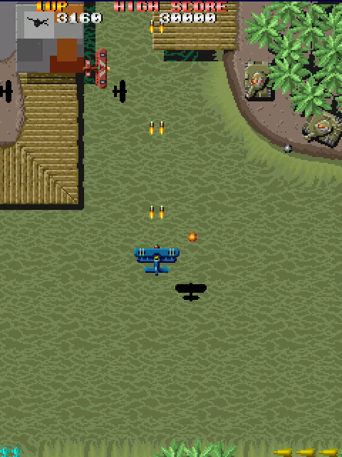 Eine Top-Down-Arcade-Spielszene mit einem blauen Flugzeug im Zentrum, das feuert. Panzer und Strukturen befinden sich im Hintergrund.