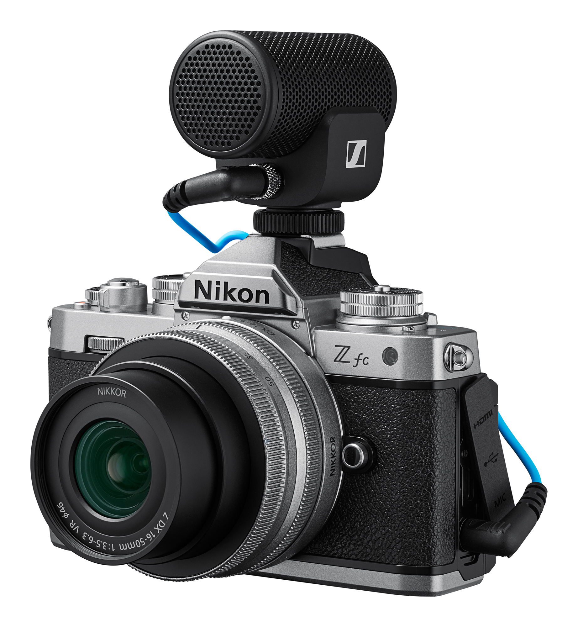 Mikrofon takılı Nikon Z fc kamera. Gümüş gövde, siyah tutamak. Yeşil iç kısma sahip siyah lens.