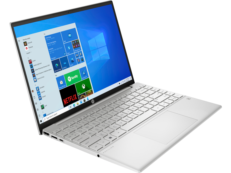 Portátil plateado con pantalla de aplicaciones de Windows 10 y teclado blanco, sobre superficie negra.