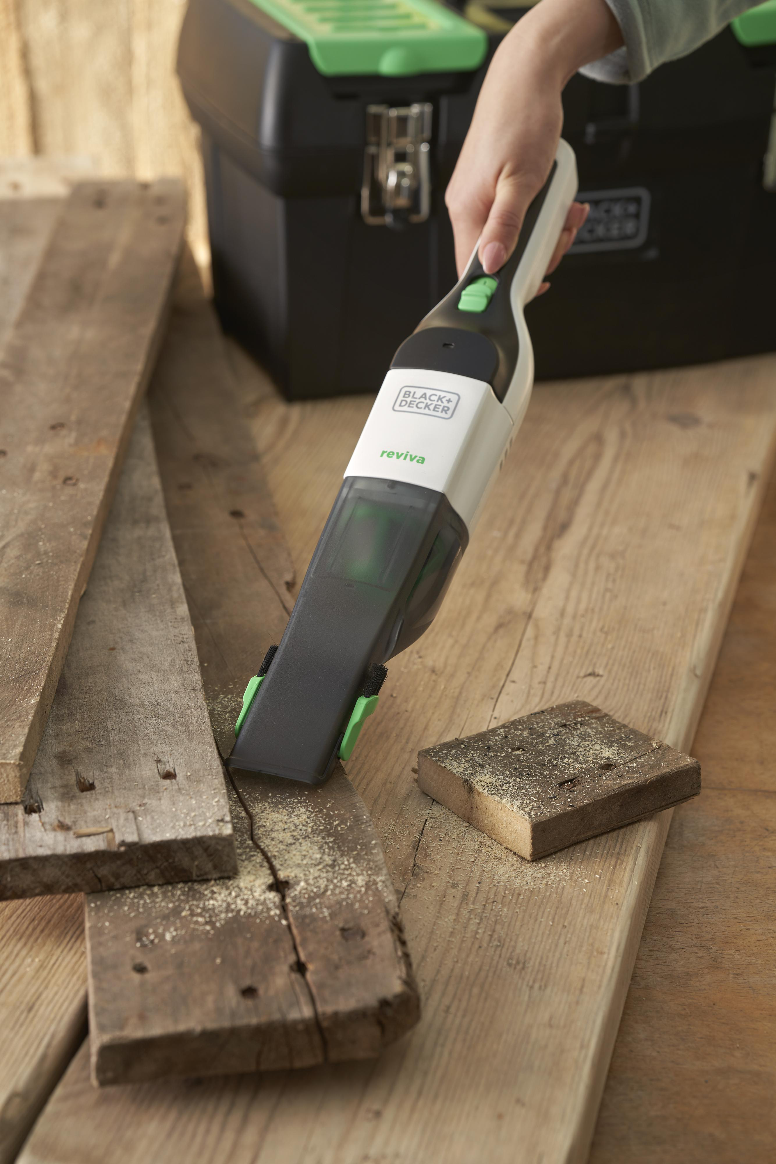 Person verwendet einen BLACK+DECKER reviva Handstaubsauger.
