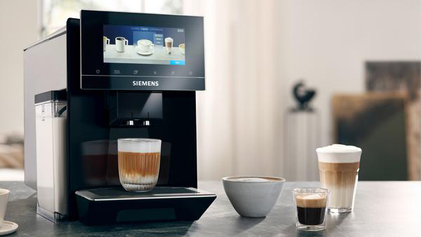 Kaffeemaschine mit Latte im Glas, Kaffee in der Schüssel, Espresso im Glas. Weißer Hintergrund.
