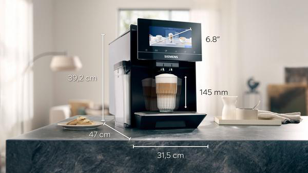 Eine Kaffeemaschine mit angegebenen Abmessungen und einem Glas Latte.