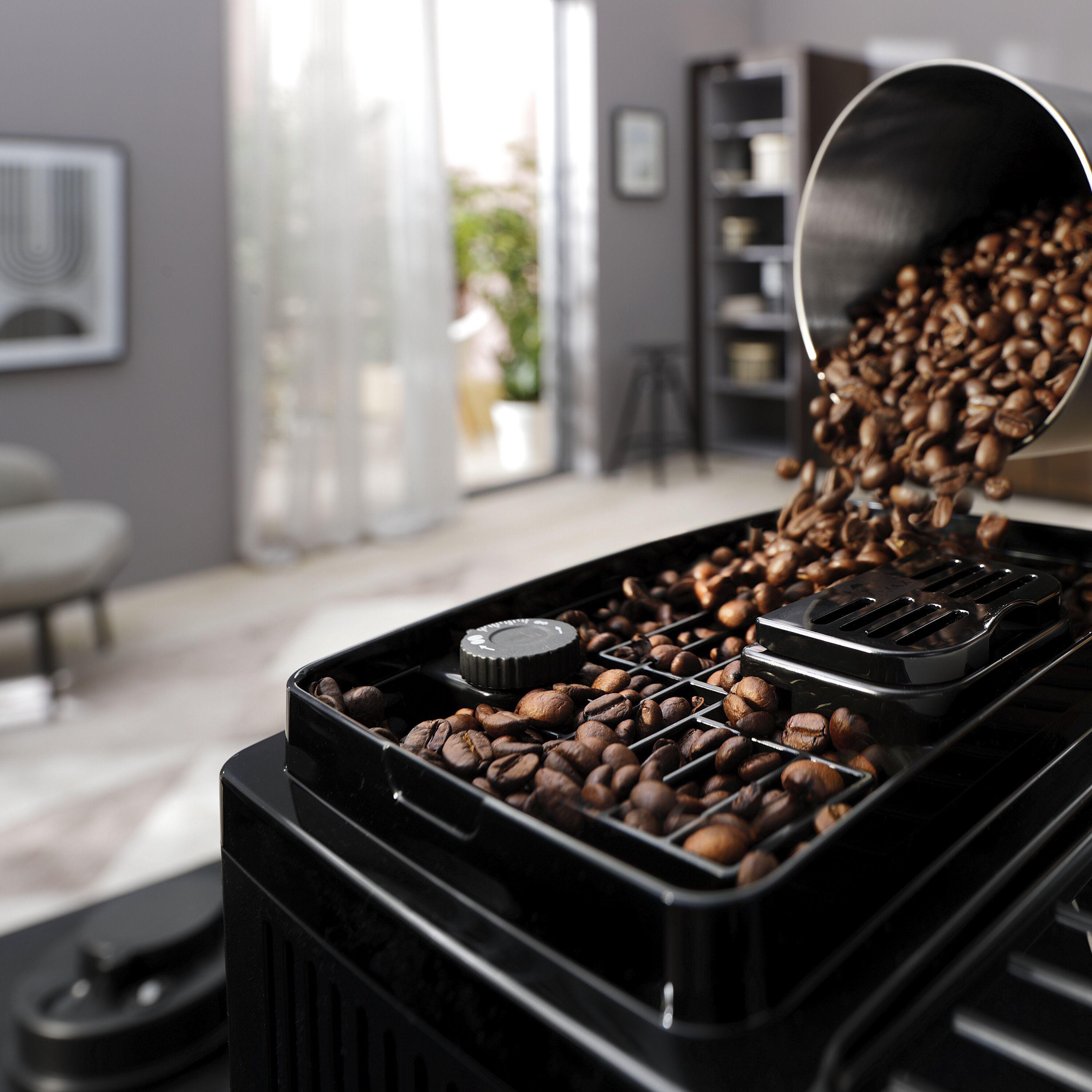 Kaffeebohnen gießen in eine Kaffeemaschine. Schwarze Maschine. Braune Bohnen.