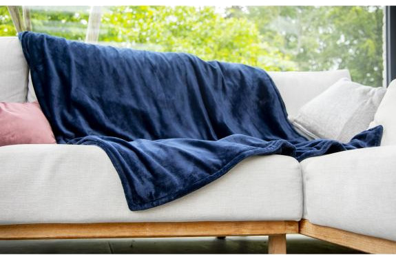 Blue blanket draped on a white sofa. Pink pillow on the left.