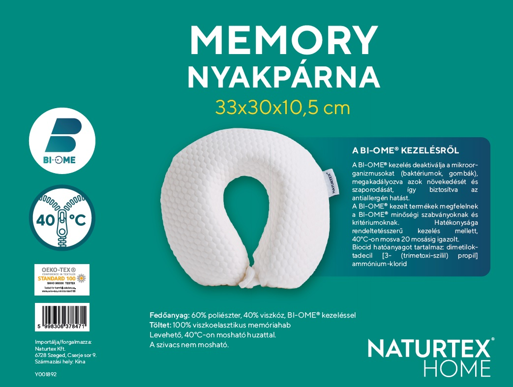 Fehér memóriahabos párna szöveggel és címkékkel, a párna zöld háttér előtt van.