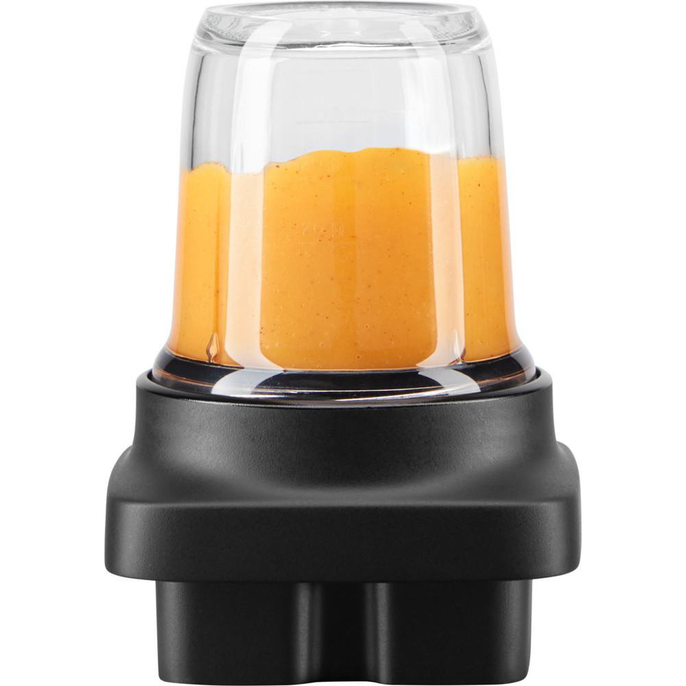 Nahaufnahme eines Mixbechers mit orangefarbener Flüssigkeit. Der Becher ist klar mit schwarzem Boden. Die Flüssigkeit füllt den Becher.