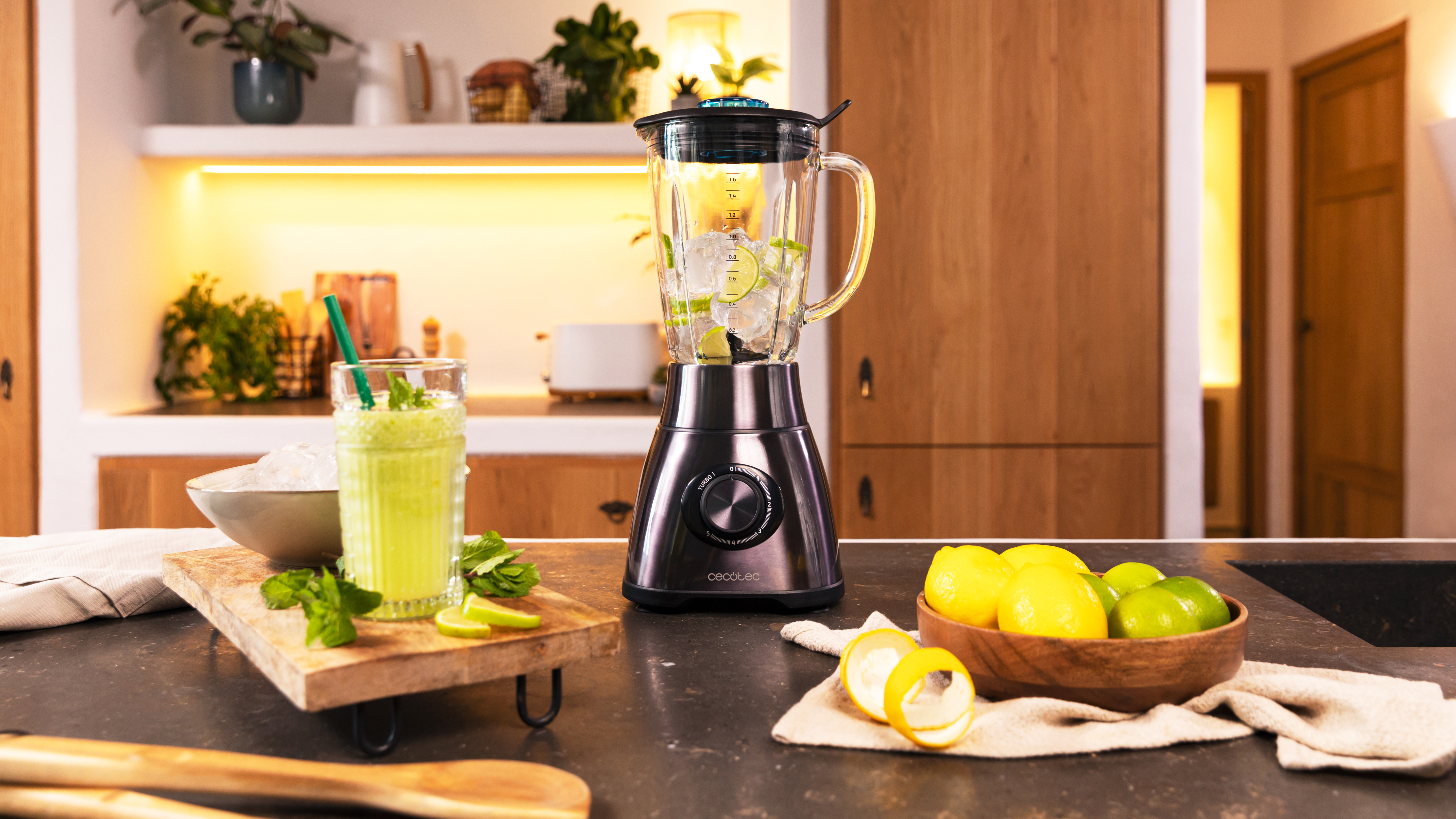Una licuadora con ingredientes y un batido en un vaso. Un ambiente de cocina con gabinetes de madera y una encimera.