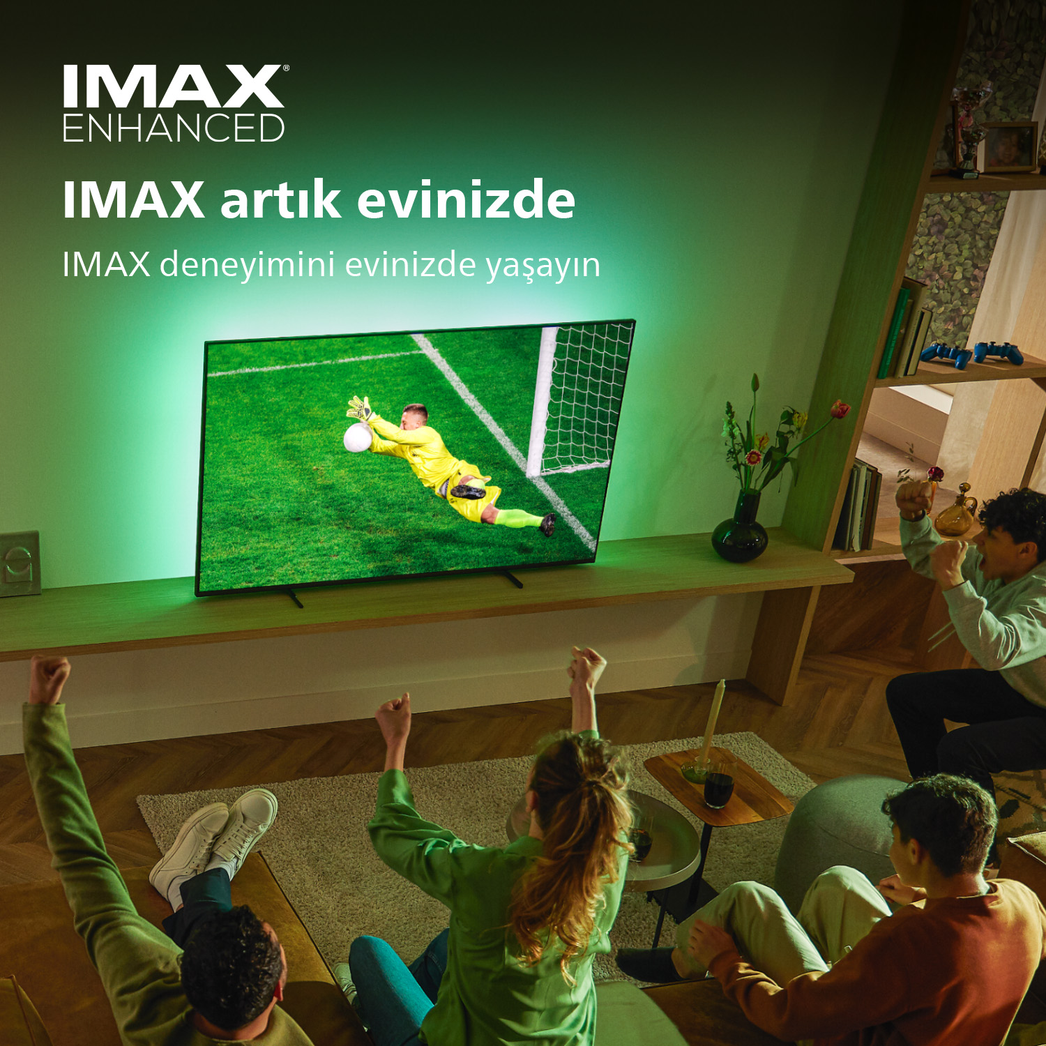 İnsanlar büyük bir TV'de futbol maçı izliyor. TV'de bir futbol maçı gösteriliyor. Neşelenen hayranlar.