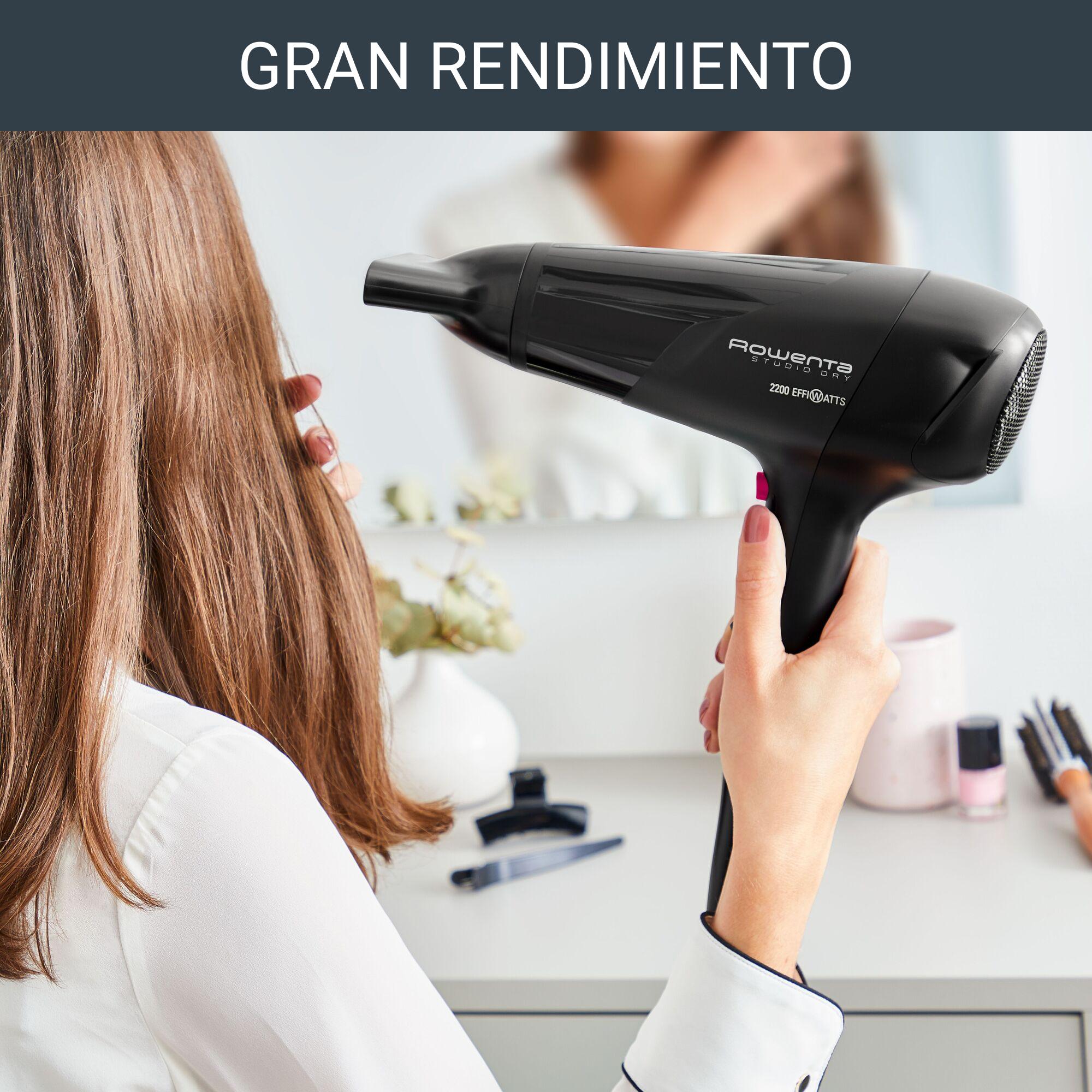 Mujer usando un secador de pelo negro, reflejo en espejo, con texto: 'GRAN RENDIMIENTO'.