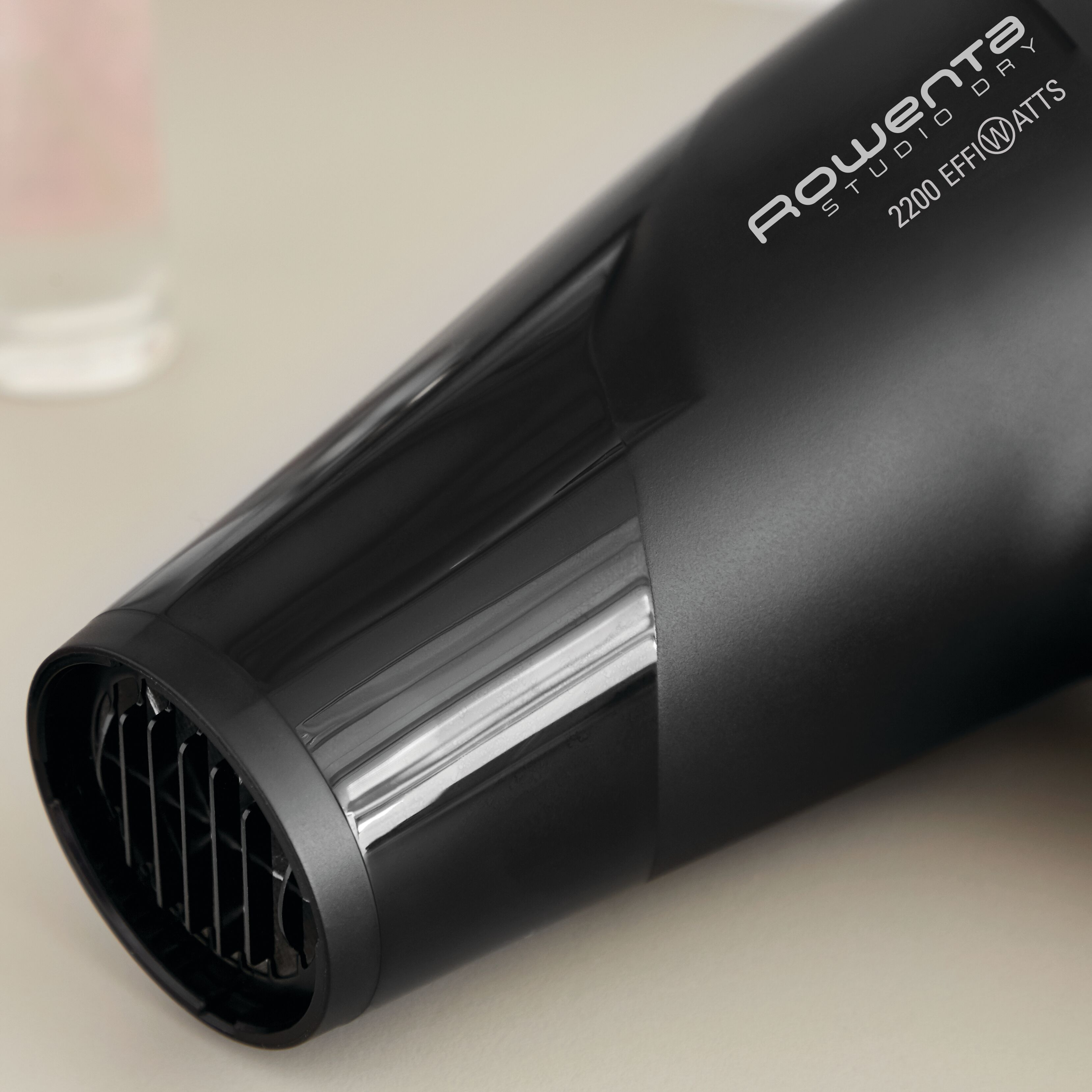 Primer plano de un secador de pelo negro. Presenta una ventilación y la marca Rowenta.