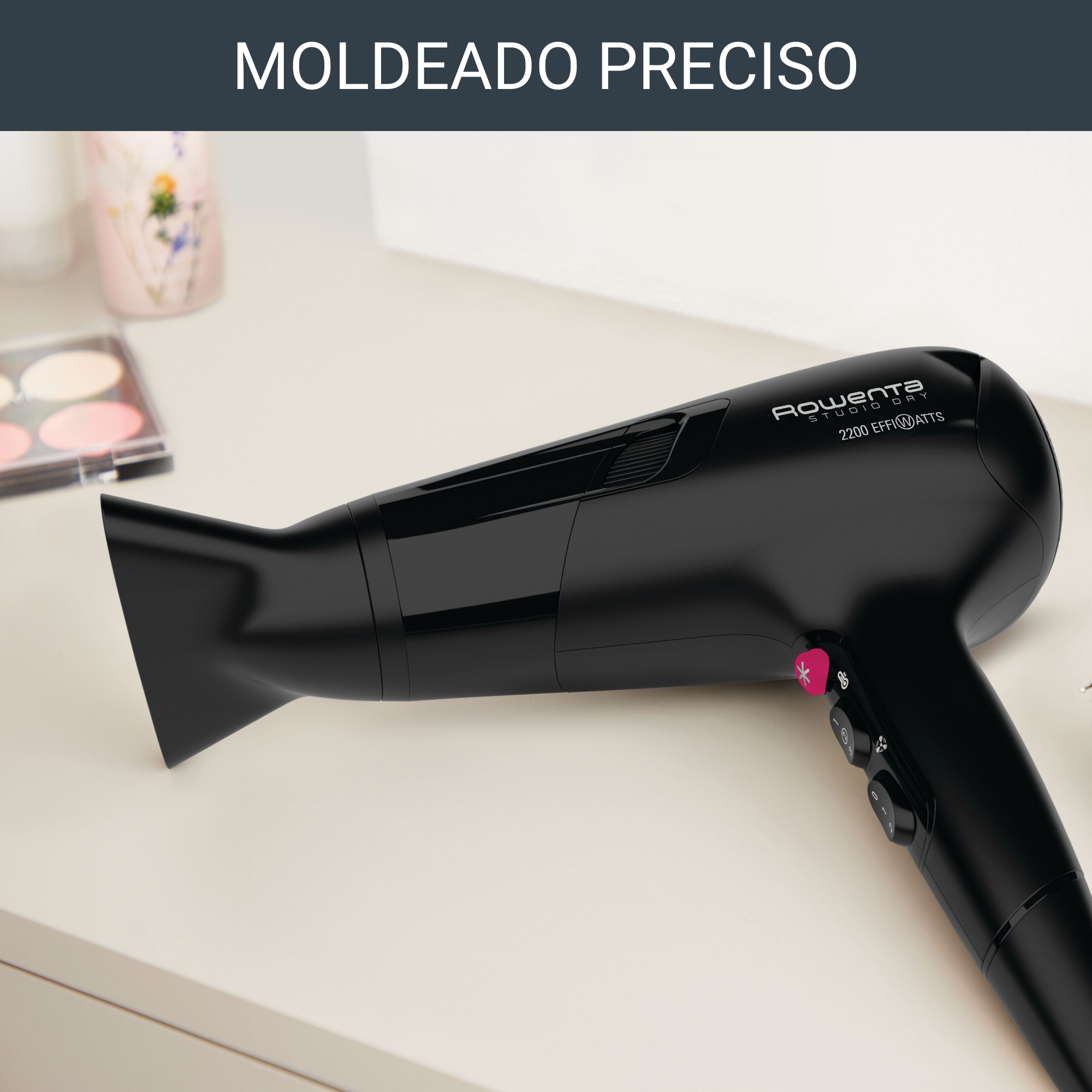 Primer plano de un secador de pelo negro sobre una superficie blanca. Botón rosa y tres botones.