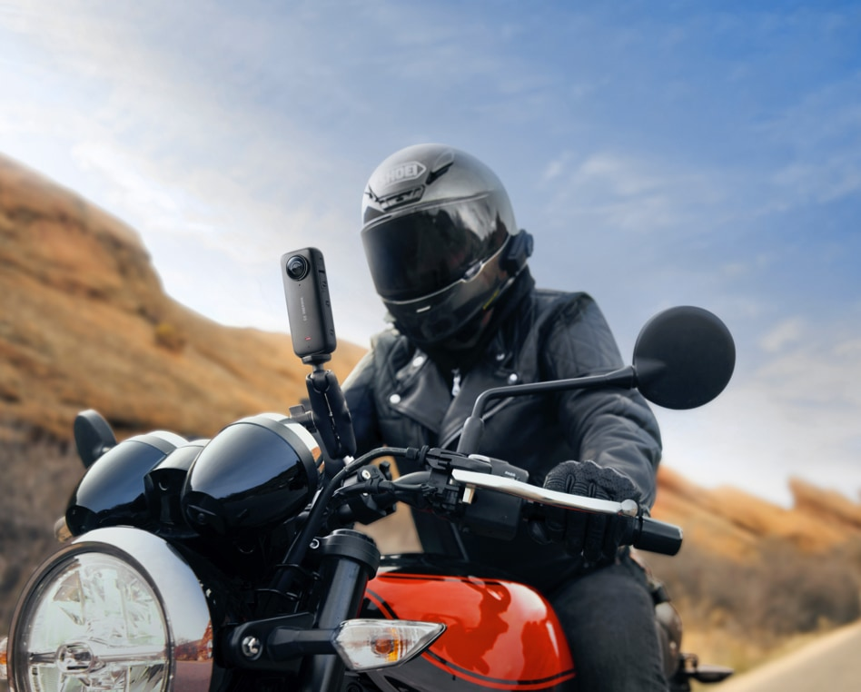 Eine Person auf einem Motorrad mit einer an den Lenker angebrachten Kamera.