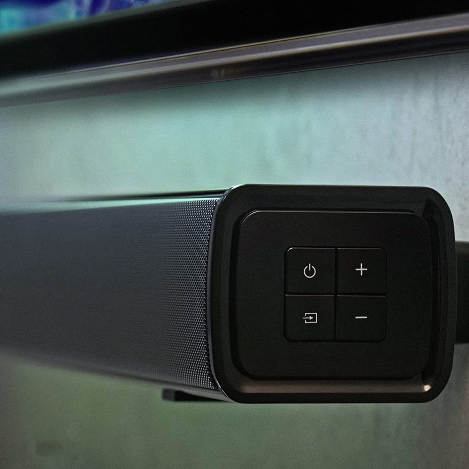 Soundbar nera con pulsanti di controllo. Montata a parete.