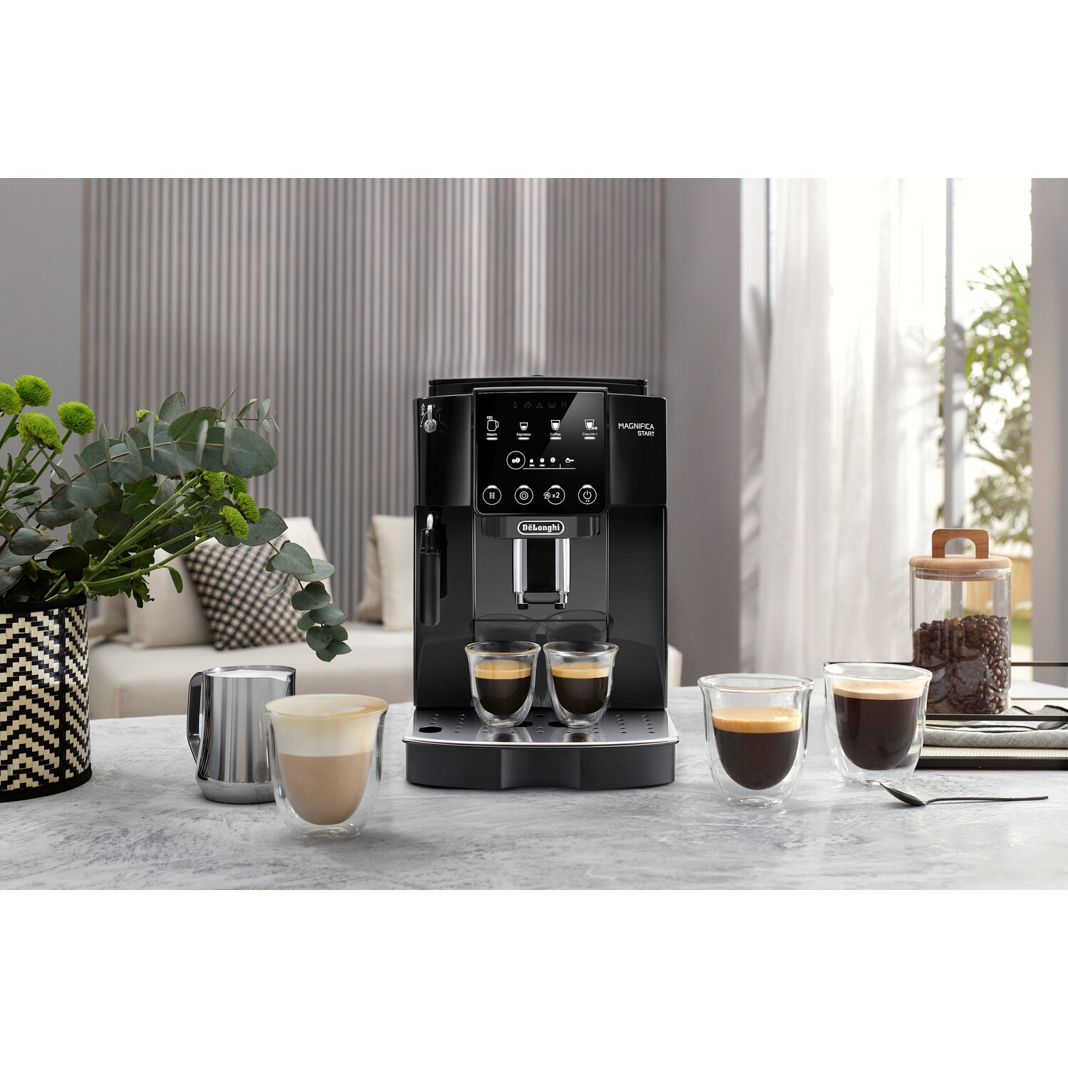 Macchina caffè nera con due tazze e altri accessori per il caffè.