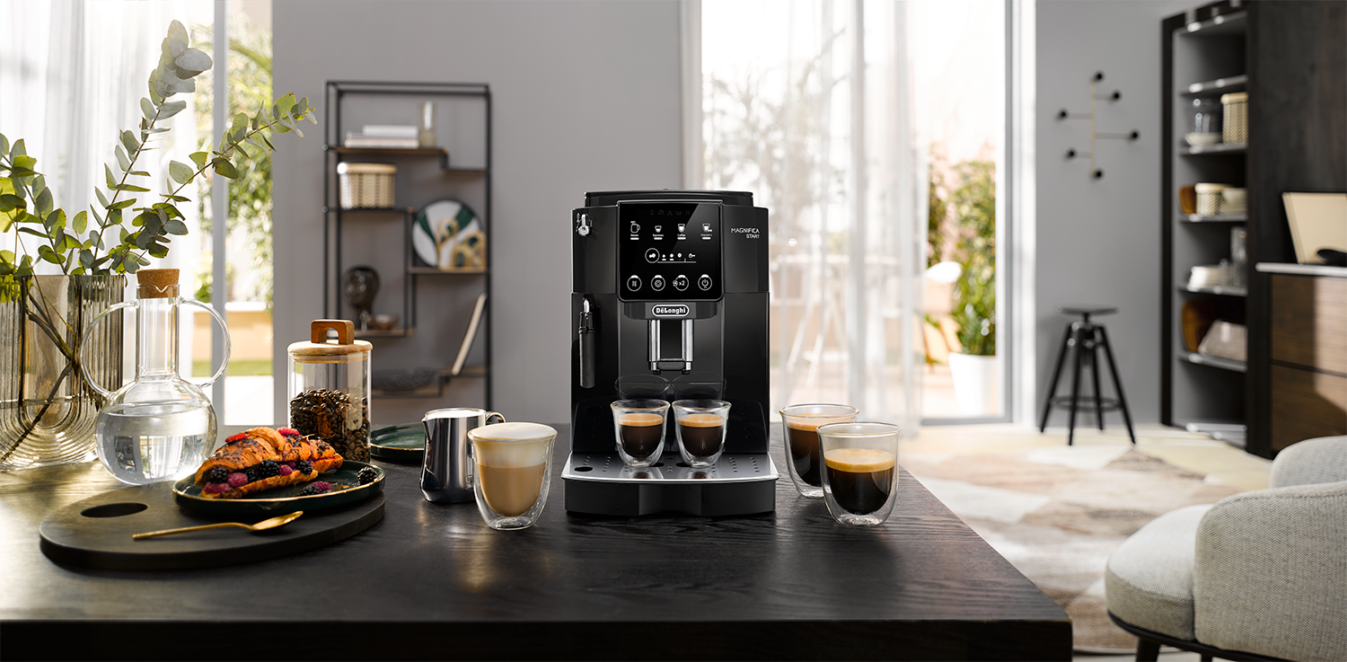 Espresso machine with coffee and food on a black table, in kitchen.