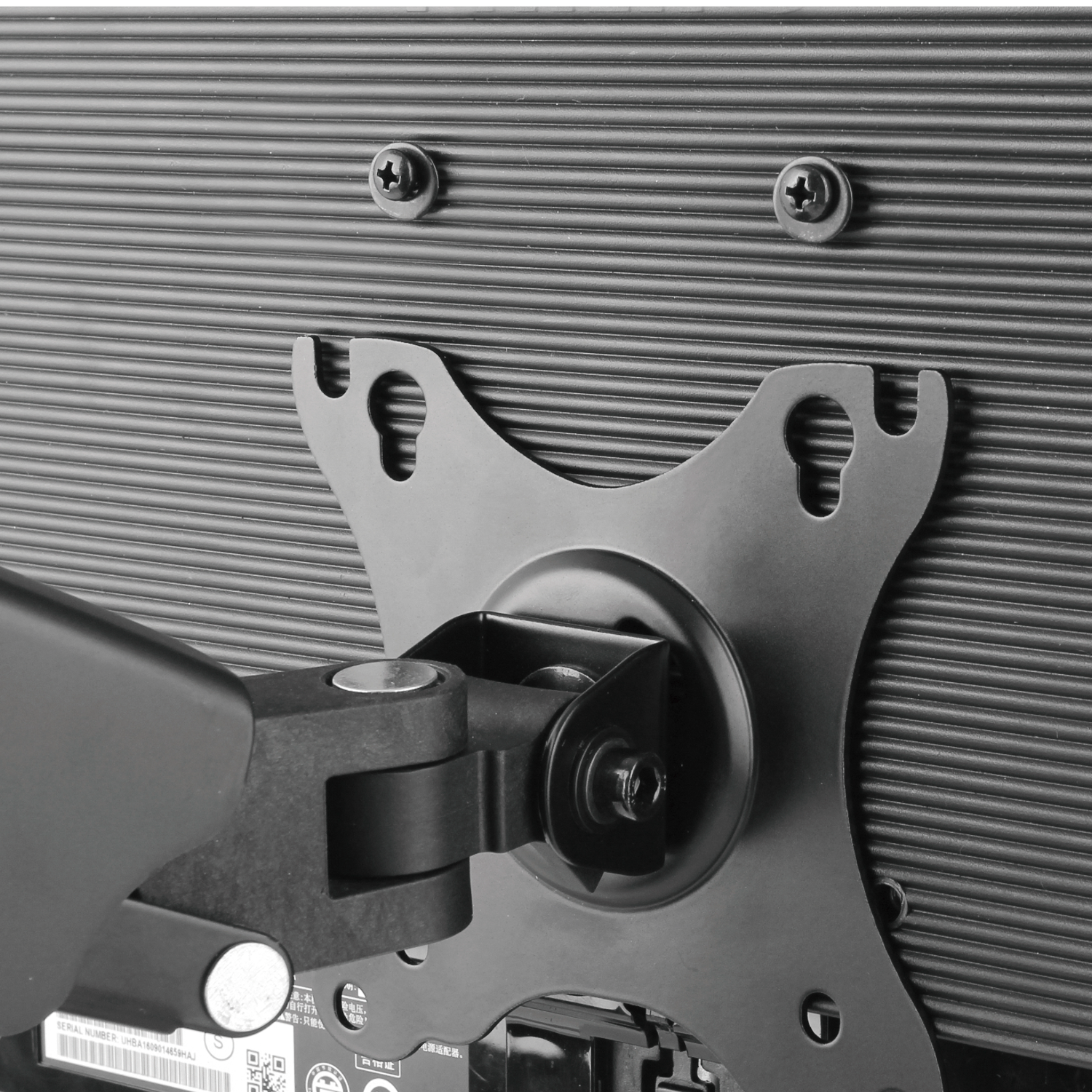 Close-up of a black metal bracket attached to a monitor.