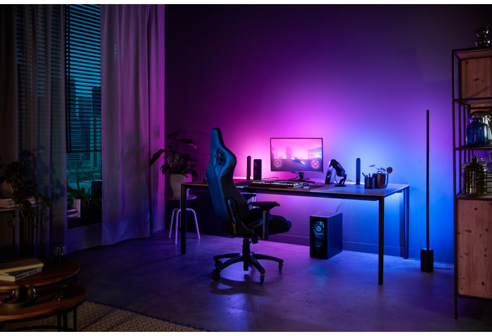 A gaming setup with a computer, monitor, chair, and lighting, all with a purple and blue theme.