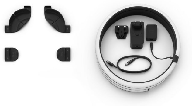 Arrangement of black accessories: charging base, charging cable and adapter, two wall mounts, and two ear hooks.
