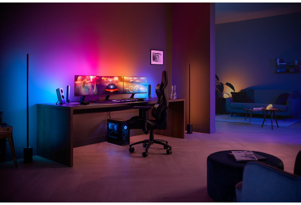 A gaming setup with multiple monitors, speakers, PC, and a gamer's chair.