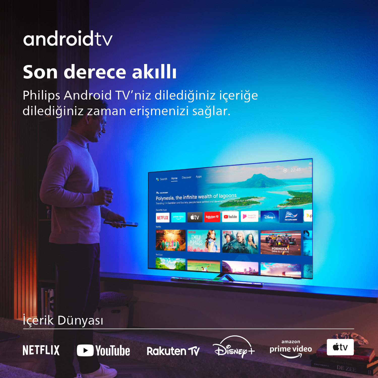 Büyük bir TV ekranının önünde uzaktan kumanda tutan bir adam.