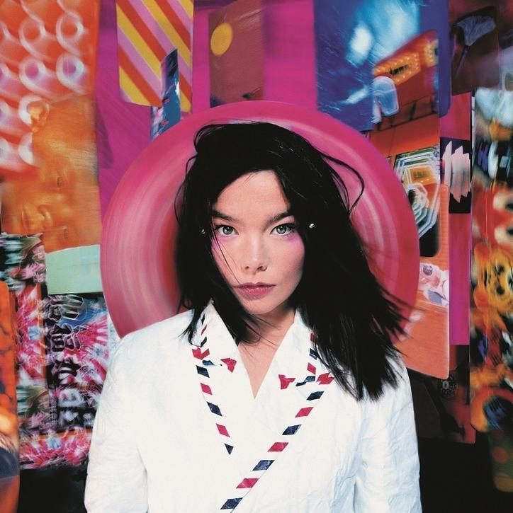 Bjork fehér inget visel színes csíkokkal egy rózsaszín kör körül.