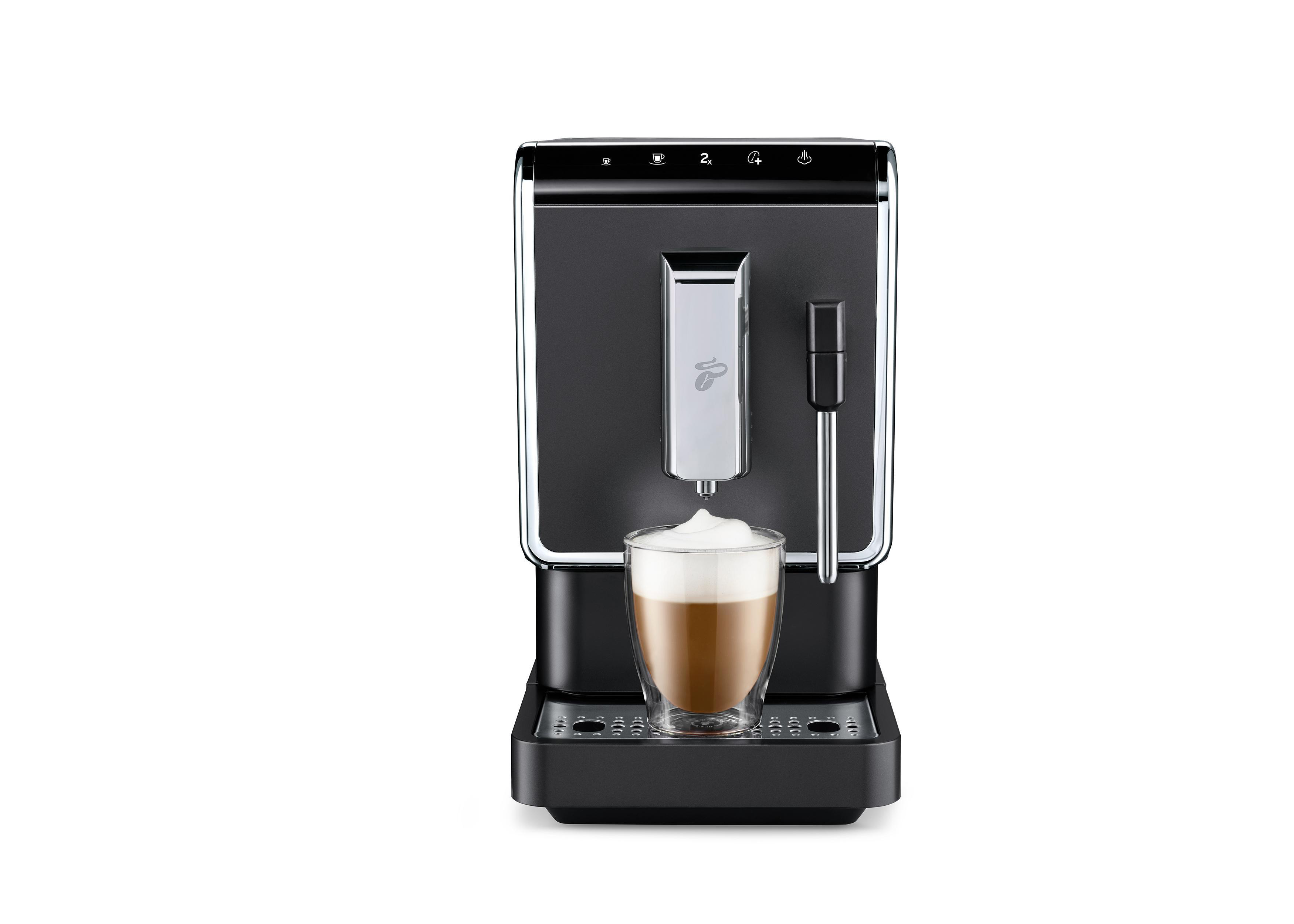Schwarze Kaffeemaschine, die Kaffee in ein Glas brüht. Schaum oben.
