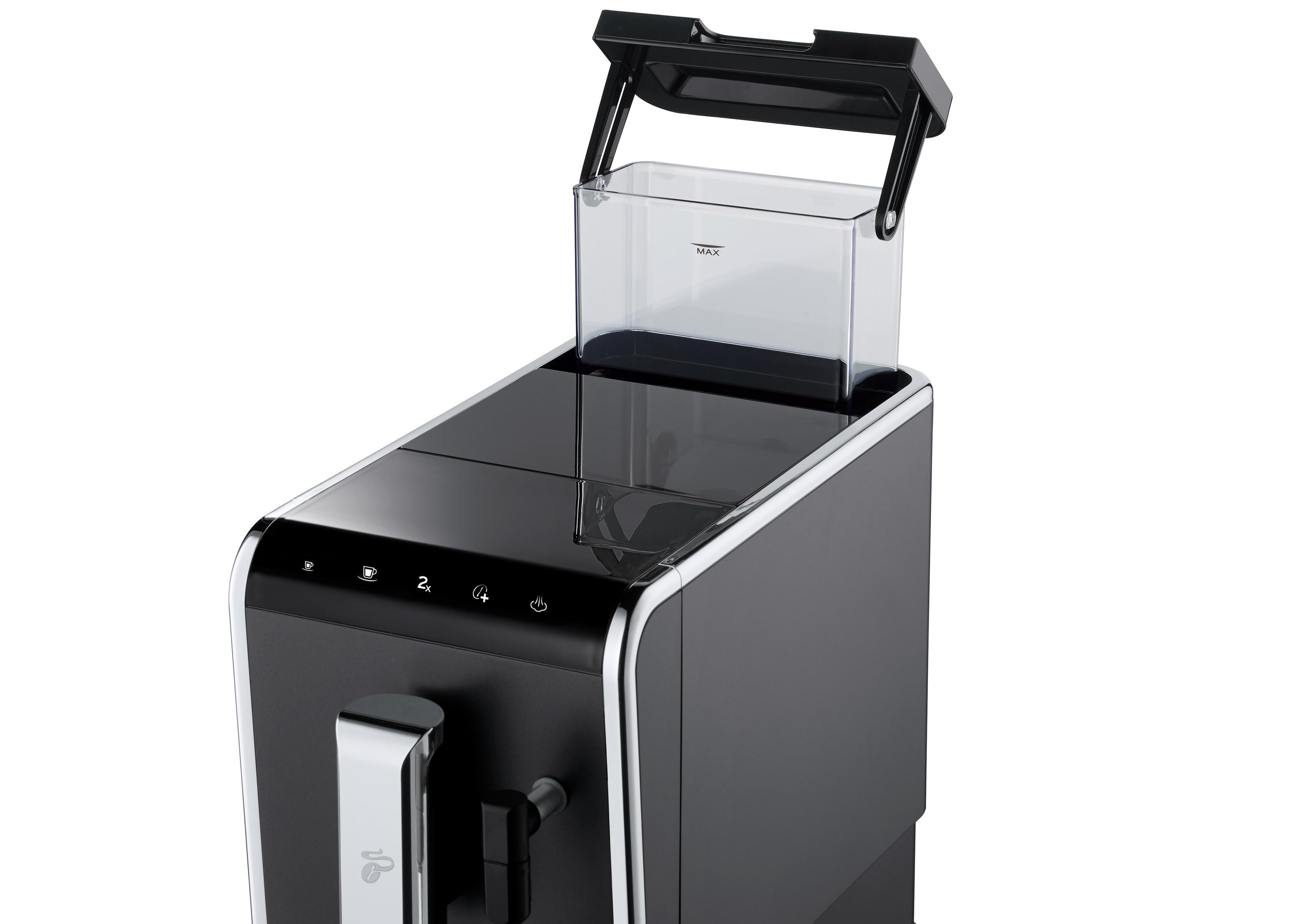 Eine schwarze Kaffeemaschine mit transparentem Wasserbehälter. Die Oberseite ist offen, Wasserstand sichtbar.