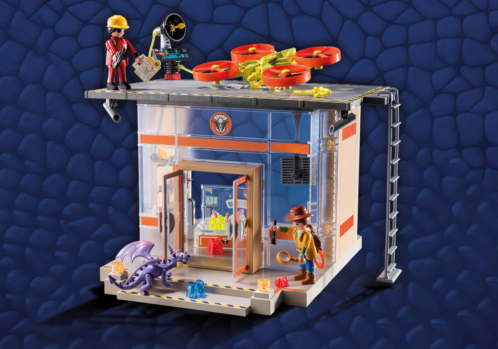 Ein Playmobil-Set zeigt ein Gebäude mit einem Drachen und zwei Figuren, eine hält ein Lasso.