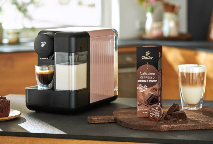 Bir fincan kahve ve çift çikolatalı espresso kapsülü ile espresso makinesi.