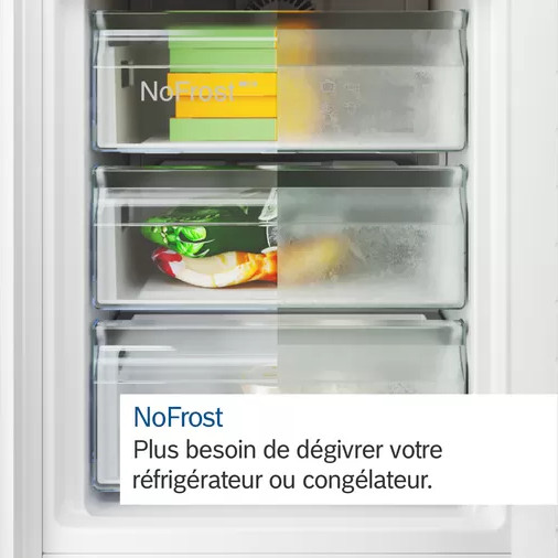 Een close-up van het interieur van een koelkast met vriesladen. Tekst over NoFrost-technologie.