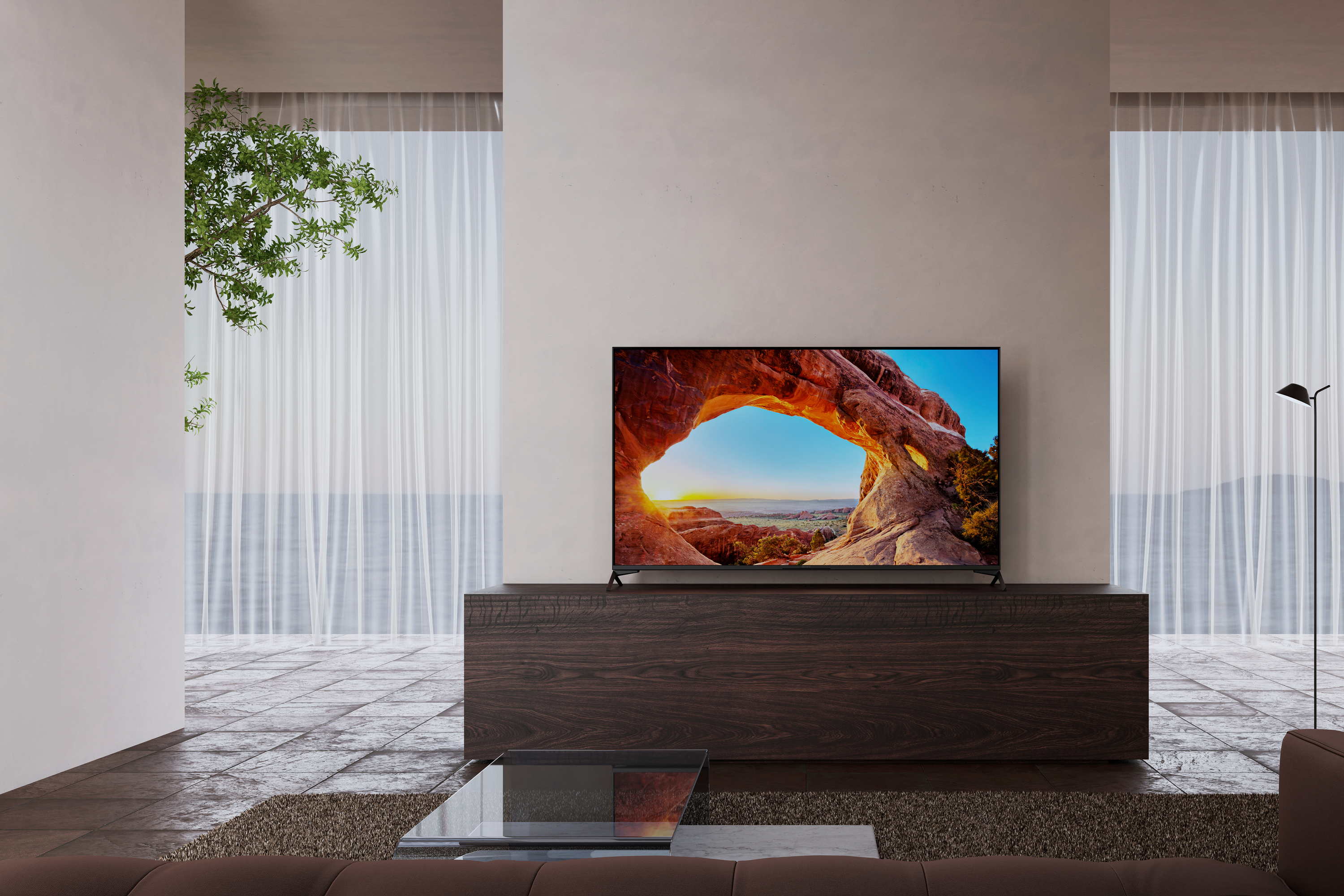 Ahşap bir dolap üzerinde bir manzara sergileyen bir TV. Beyaz perdeler manzarayı çerçeveliyor.