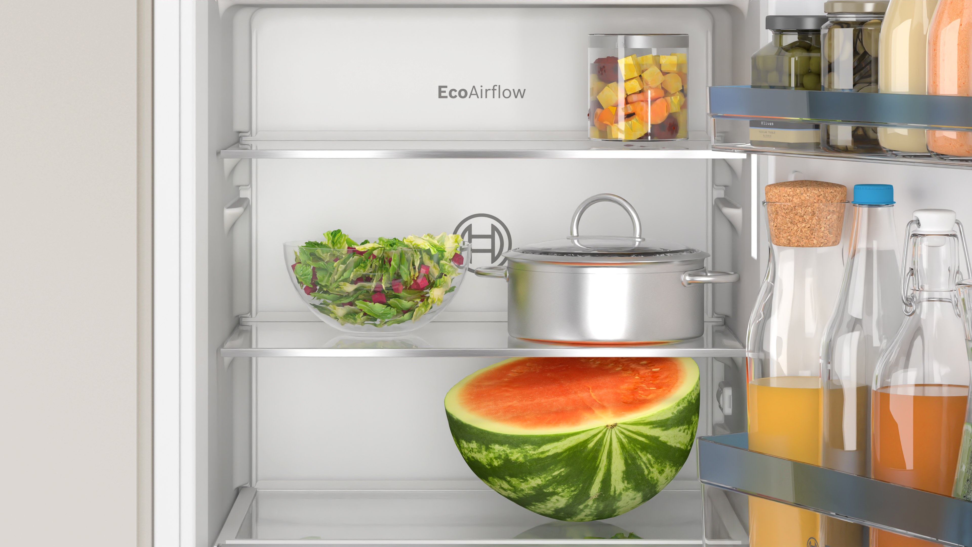 Kühlschrankinnenraum mit Regalen, die Salat, Wassermelone und andere Lebensmittel halten.