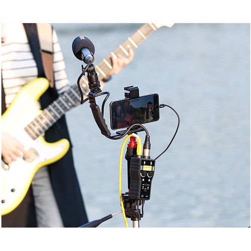 Bir kişi, bir gitarına bağlı bir telefon ve mikrofonla çekim yapıyor.