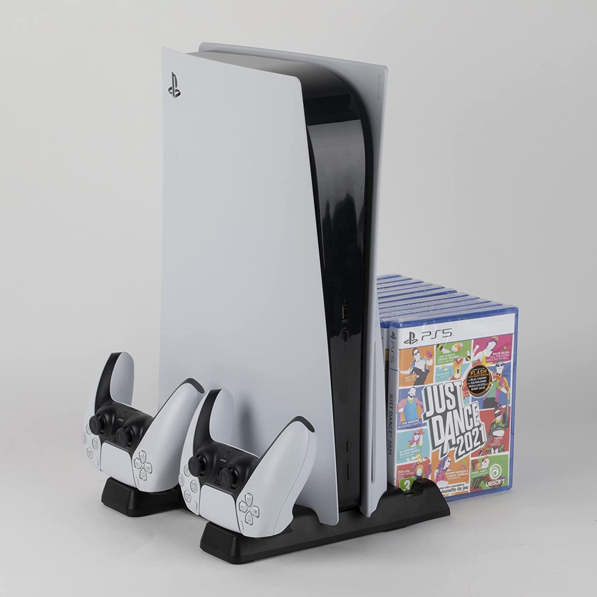 Une console Playstation 5 avec deux manettes et le jeu Just Dance 2021.