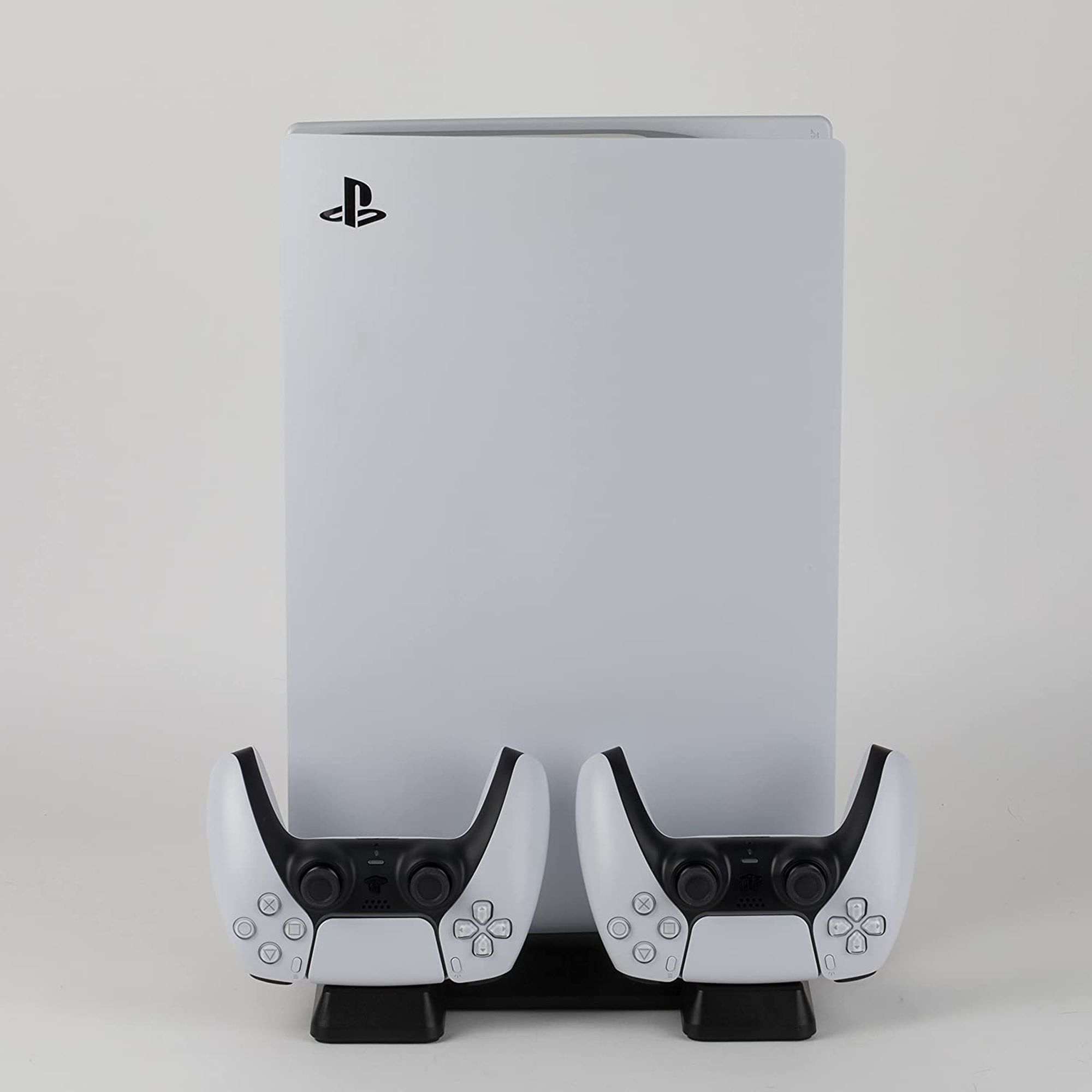 Une Playstation 5 blanche et deux manettes blanches.