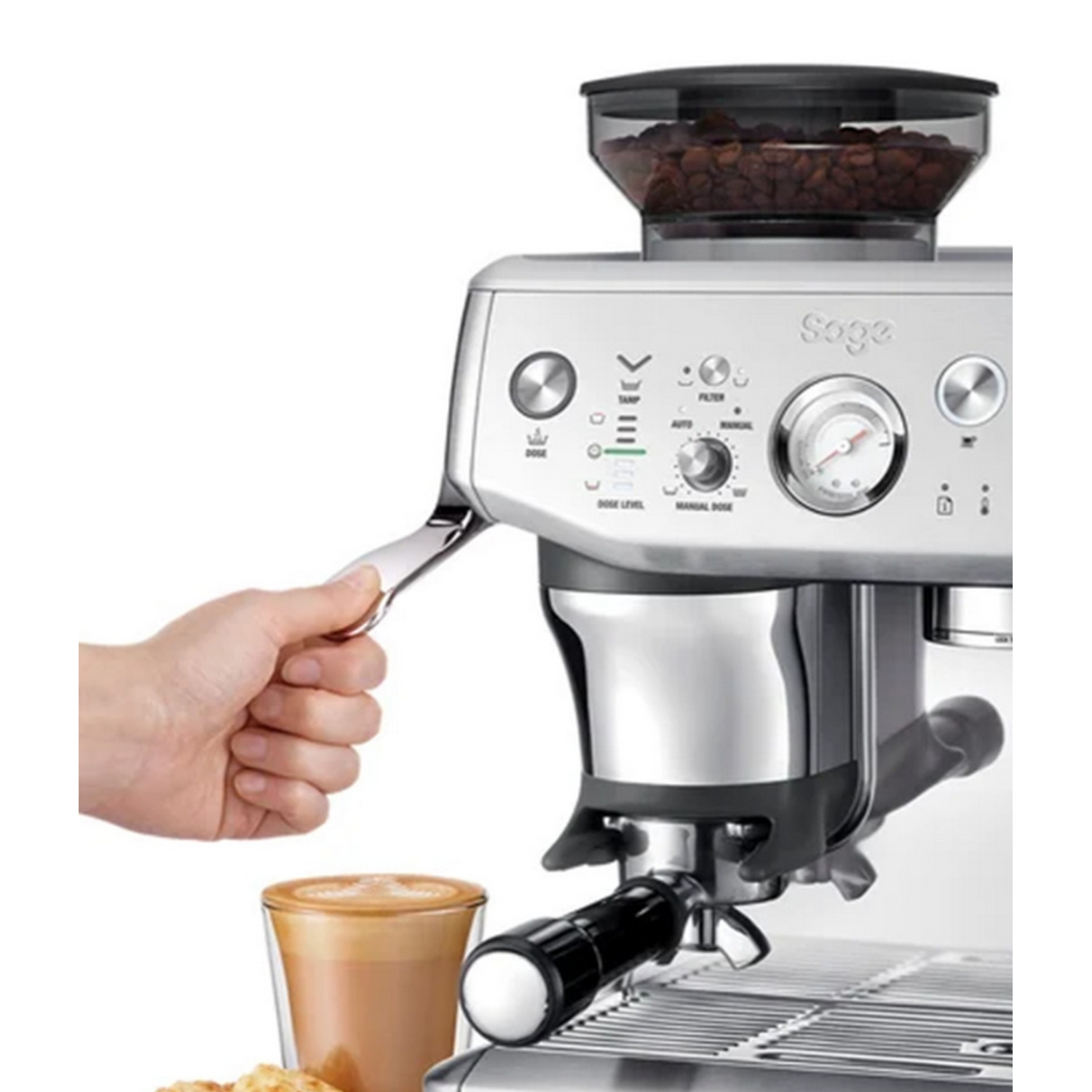 Máquina de espresso. Una mano sostiene un portafiltro, con un vaso de latte al frente.