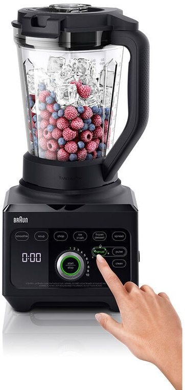 Frullatore nero con ghiaccio, frutti di bosco e una mano che preme un pulsante.