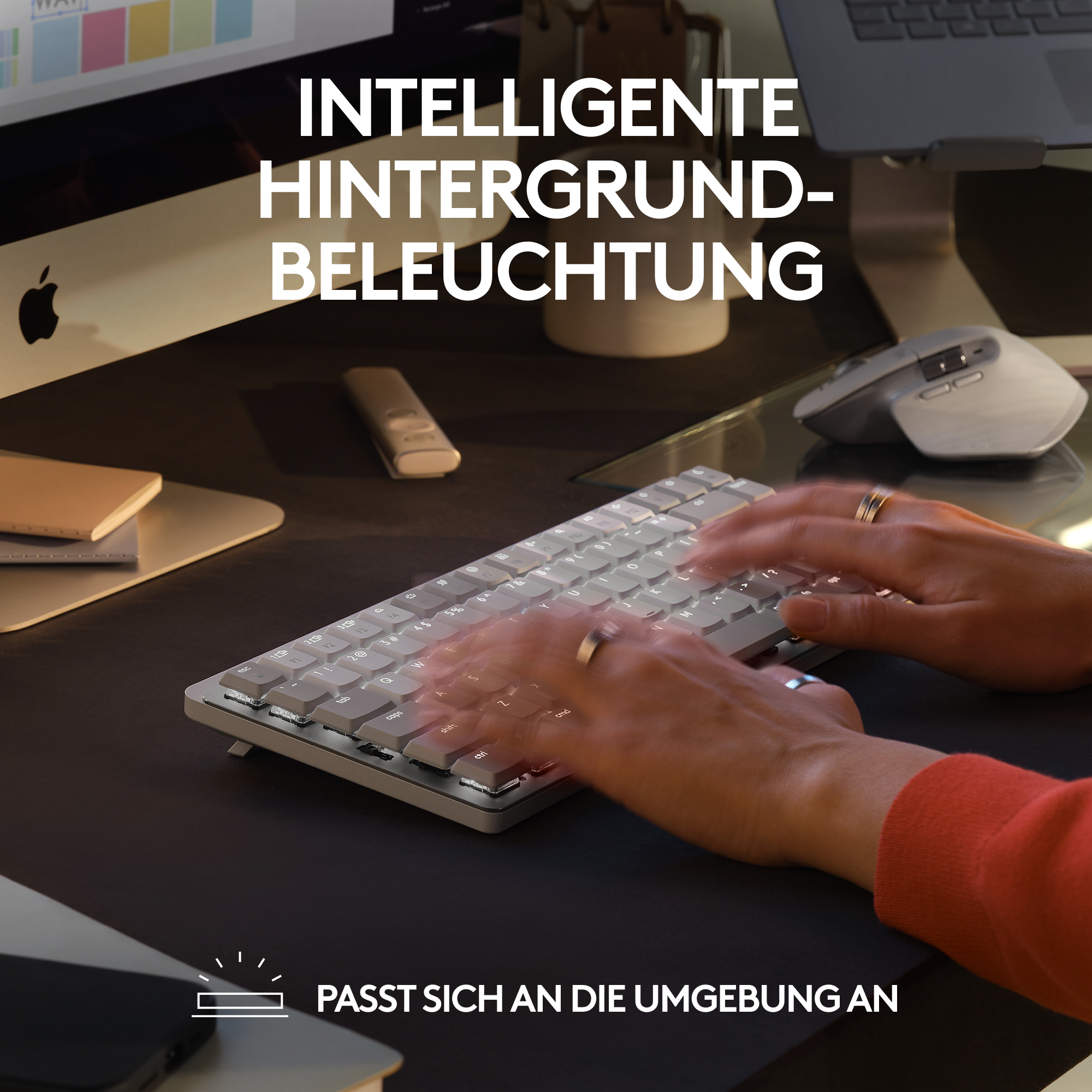 Hände einer Person, die auf einer leuchtenden Tastatur tippen. Text auf Deutsch oben. Schwarzer Hintergrund.