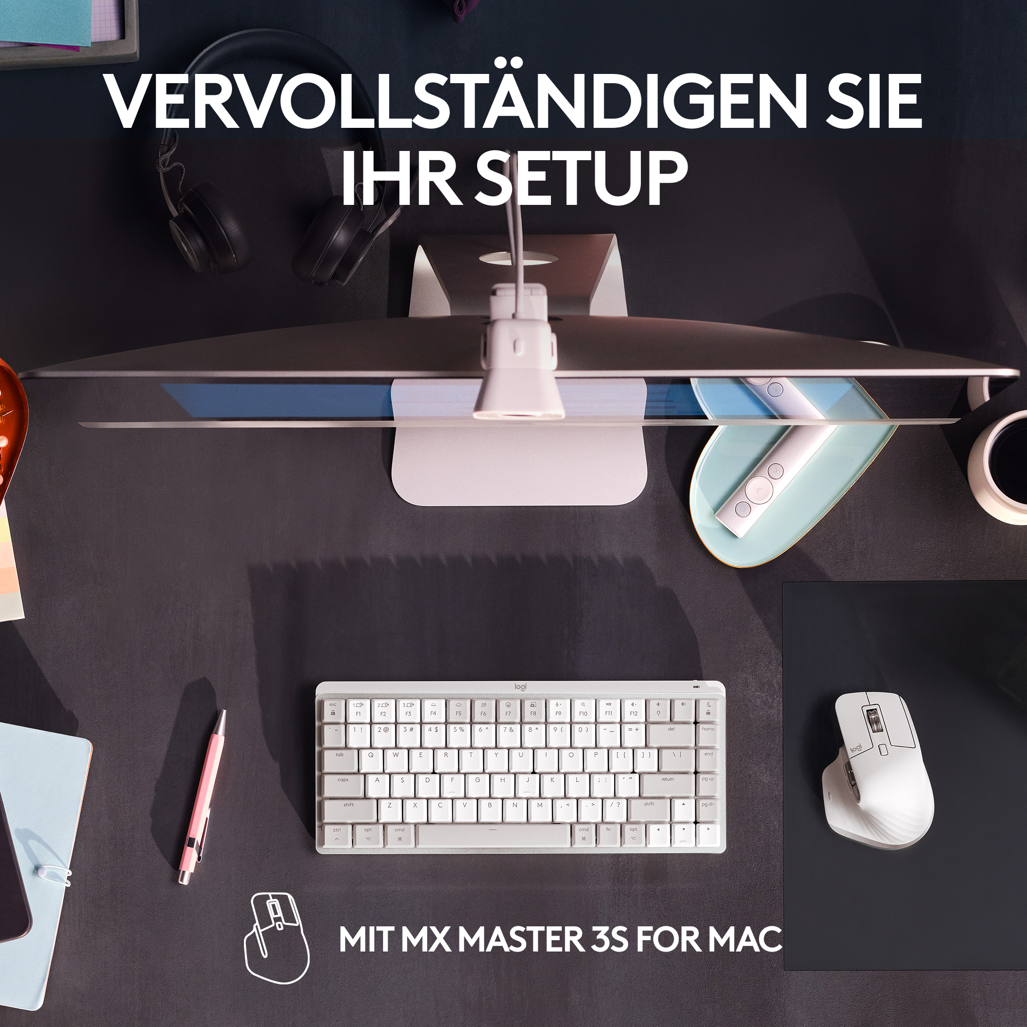Draufsicht auf einen Schreibtisch, mit Monitor, Tastatur, Maus, Stift und Notizblock.