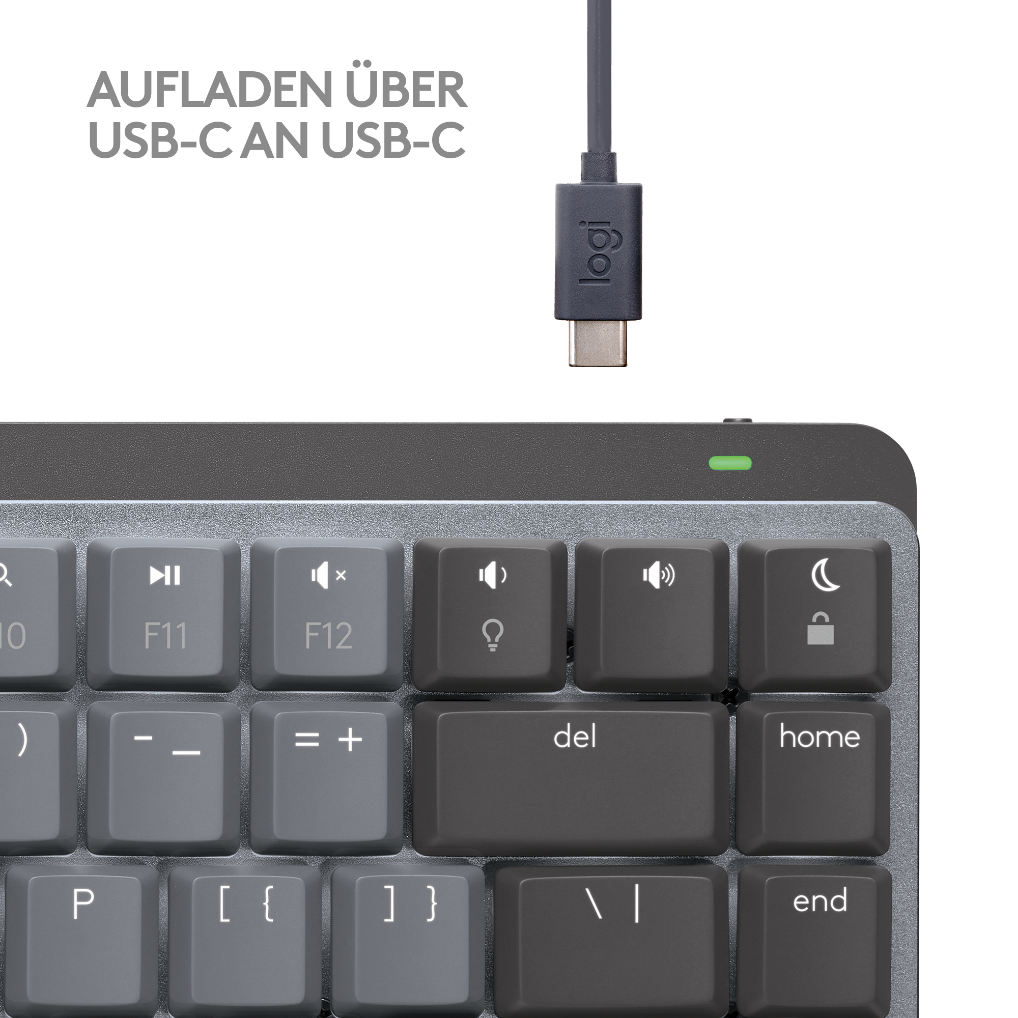 Nahaufnahme einer Tastatur mit einem Ladekabel darüber.