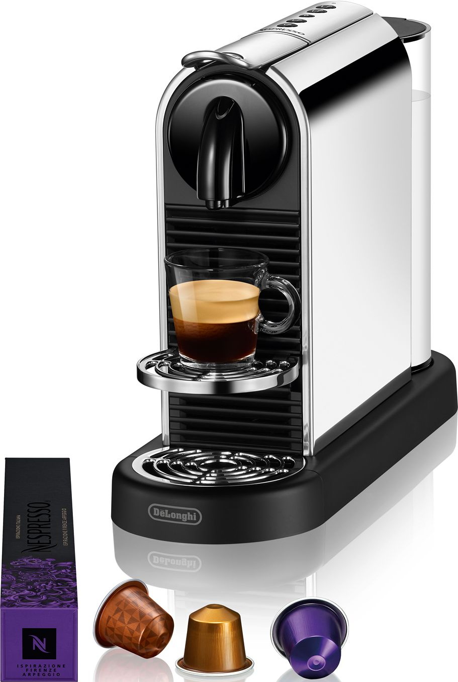 Eine silber-schwarze Nespresso-Maschine mit einem Glas Kaffee. Kapseln und eine Schachtel Nespresso-Pads befinden sich links und unten.