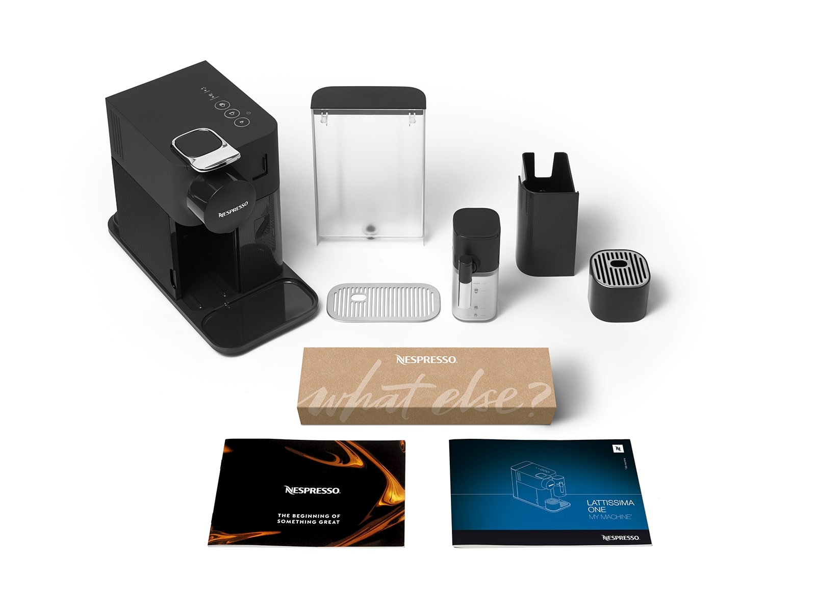 Nespresso Lattissima One makinesi ve aksesuarları, beyaz bir yüzeye yerleştirilmiş.