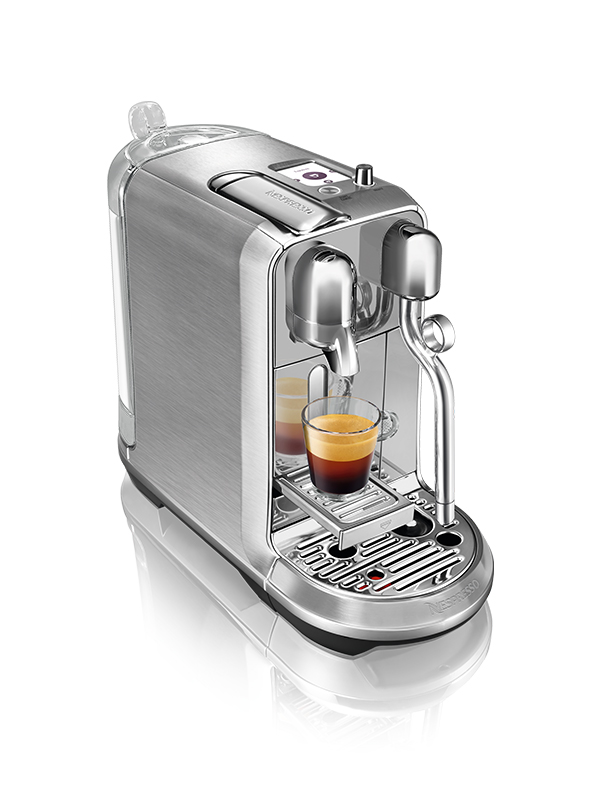 Gümüş Nespresso kahve makinesi, cam bardak ve espresso ile.
