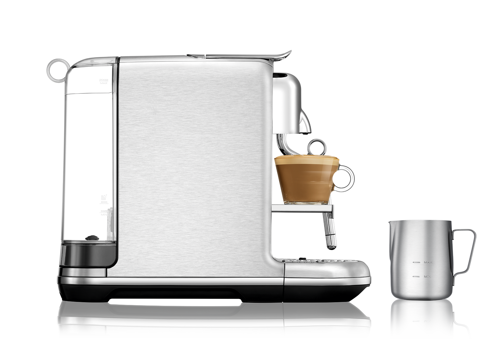 Siyah bir yüzeyde bir fincan kahve ve küçük bir süt sürahisi ile gümüş bir espresso makinesi.