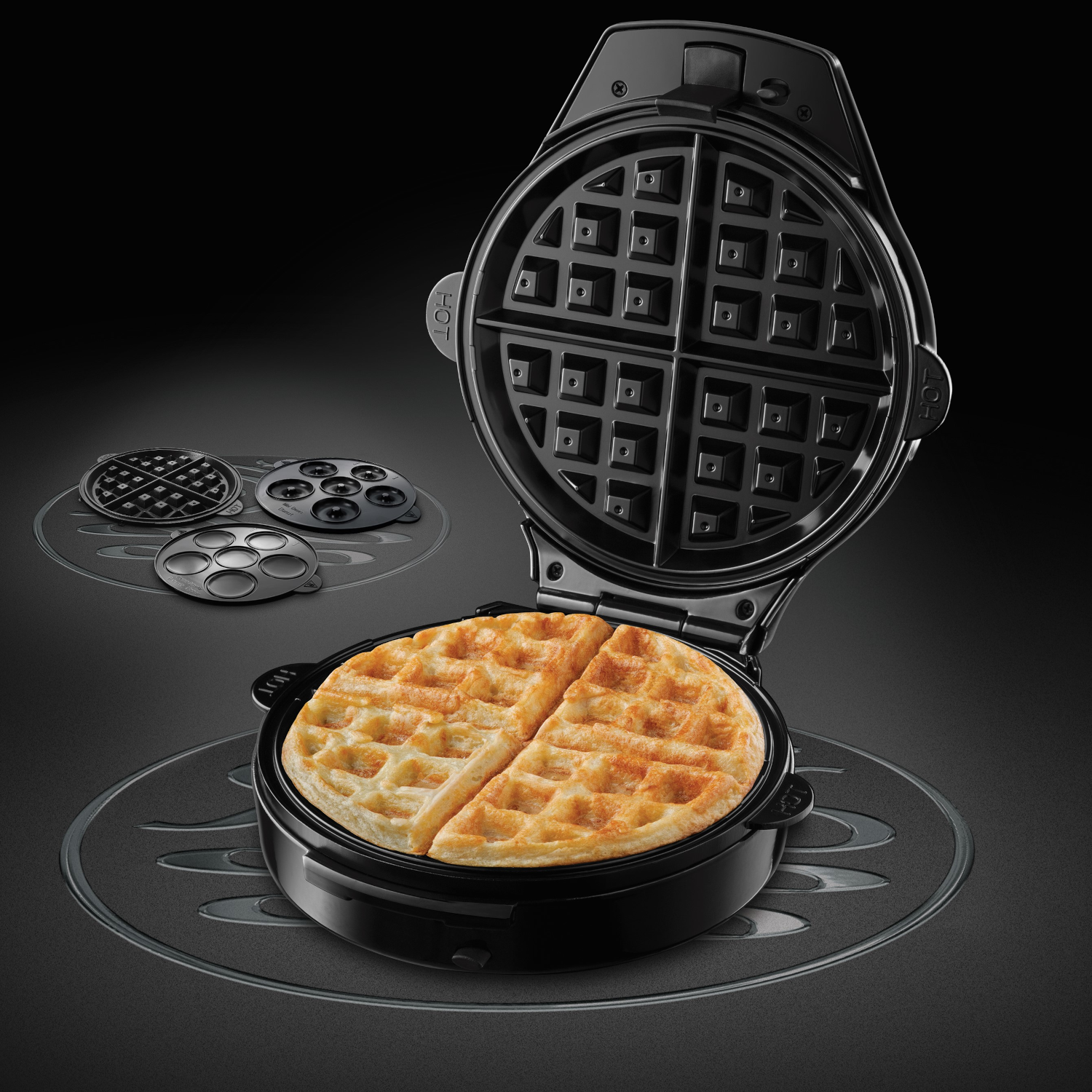 Black waffle maker, open, with a cooked waffle. Extra plates visible.