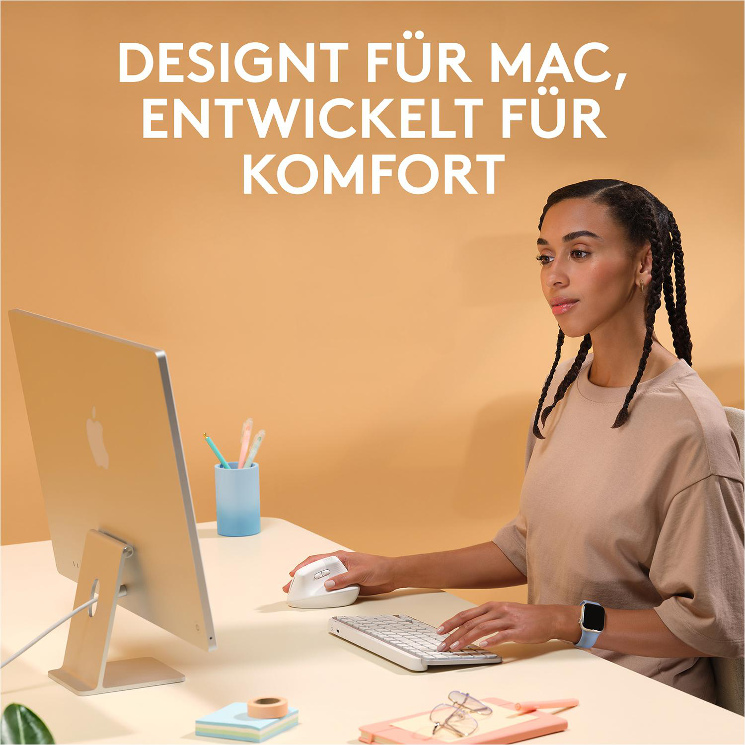 Eine Frau benutzt einen Computer mit Tastatur, Maus und Monitor auf einem Schreibtisch.