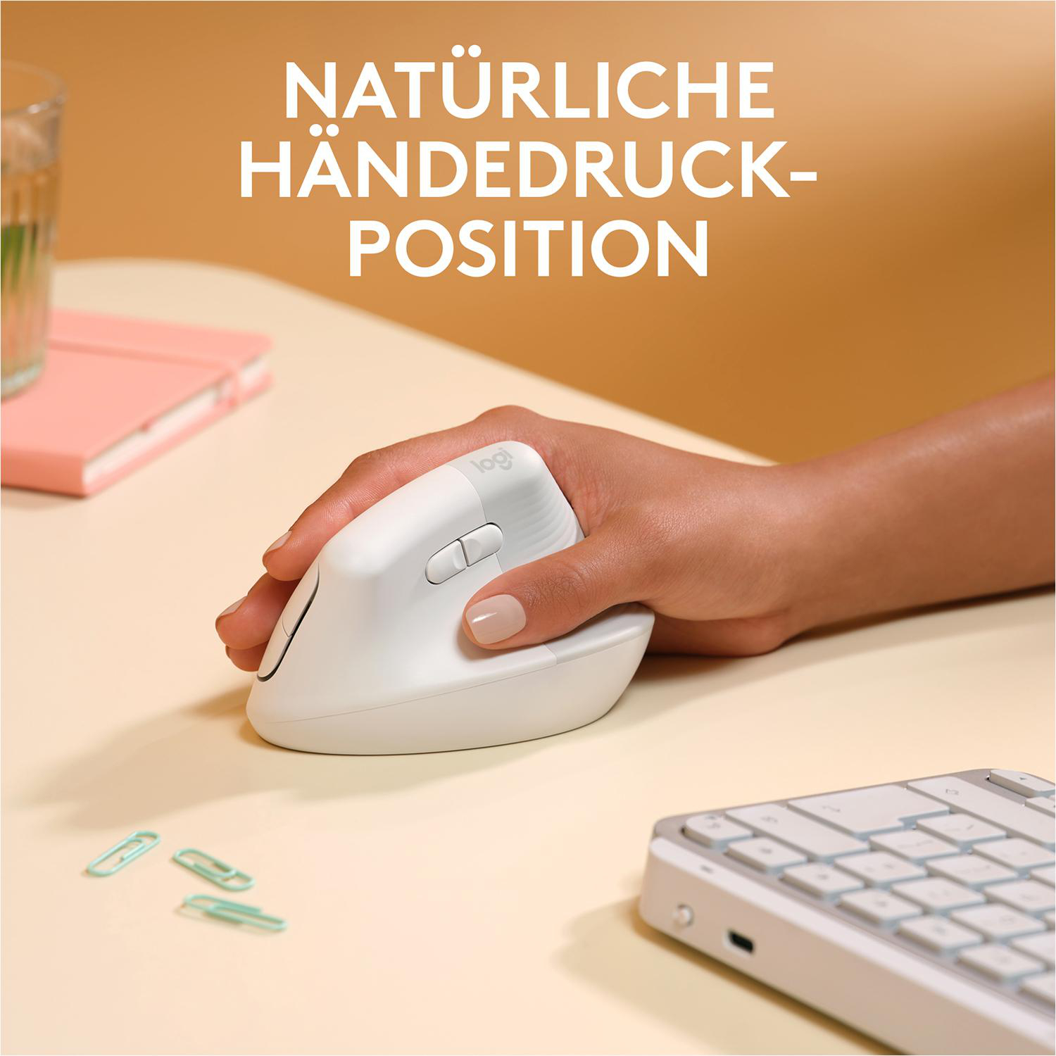 Die Hand einer Person ruht auf einer weißen ergonomischen Maus auf einem Tisch. Text: Natürliche Handposition.